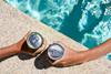 Two,Hands,Hold,Cans,Of,Cold,Drink,In,The,Pool