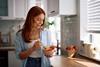 Smiling,Woman,Eating,Oatmeal,With,Fresh,Fruit,In,The,Morning.