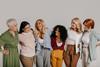 Multi-ethnic,Group,Of,Happy,Mature,Women,Embracing,Against,Grey,Background