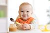 Cheerful,Baby,Child,Eats,Food,Itself,With,Spoon.,Portrait,Of