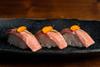 7 Trio of BlueNalu's bluefin tuna toro nigiri, topped with sliced chives and nasturtium petals