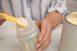Woman,Preparing,Infant,Formula,At,Table,,Closeup.,Baby,Milk