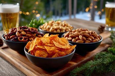 Gathering around snacks and drinks during a cozy winter evening with friends outdoors in front of festive lights