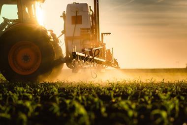 Tractor,Spraying,Pesticides,On,Corn,Field,With,Sprayer,At,Spring