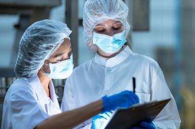 Food production staff using a digital tablet to run food safety HACCP checks