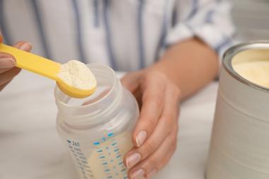 Woman,Preparing,Infant,Formula,At,Table,,Closeup.,Baby,Milk