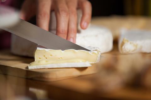 Hand,Of,Female,Staff,Cutting,Cheese,At,Counter,In,Market