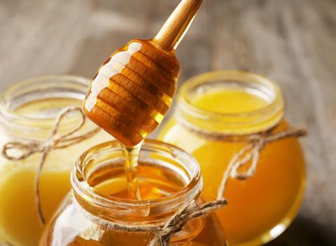 Pouring,Aromatic,Honey,Into,Jar,,Closeup