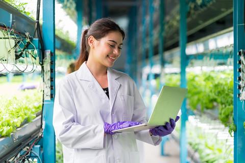 Young,Woman,Scientist,Holding,Laptop,Computer,Analyzes,And,Studies,Research