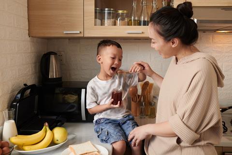 Little,Son,Sitting,On,Kitchen,Counter,And,Eating,Spoon,Of