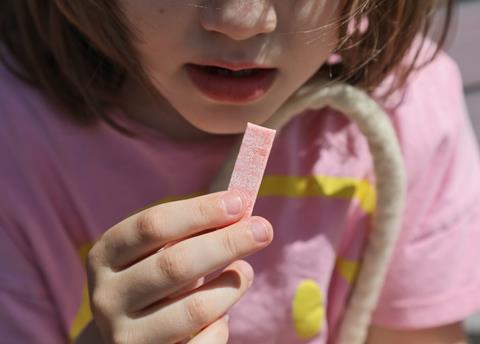 A,Piece,Of,Pink,Chewing,Gum,In,The,Girl's,Hands.