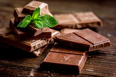 Chocolate,Pieces,With,Mint,On,Wooden,Table,Background