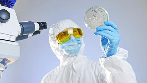 Scientist,Looks,At,A,Petri,Dish,With,Bacteria,Through,Light.