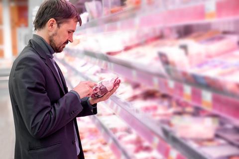 A,Bearded,Man,Reads,Information,About,The,Product,,Stands,Near