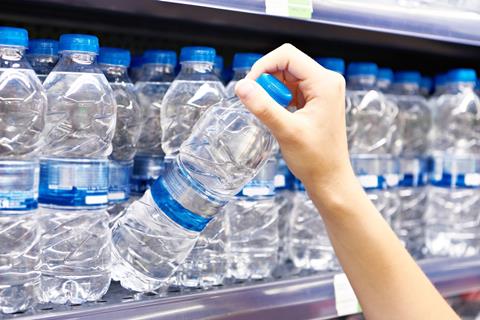 Drinking,Water,Plastic,Bottles,In,Hand,At,Store