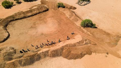 Aerial view of community members taking part in FAO's cash-for-work initiative to rehabilitate a communal water catchment, strengthening local water access and resilience in Galka’ayo, Galmudug State, Somalia.