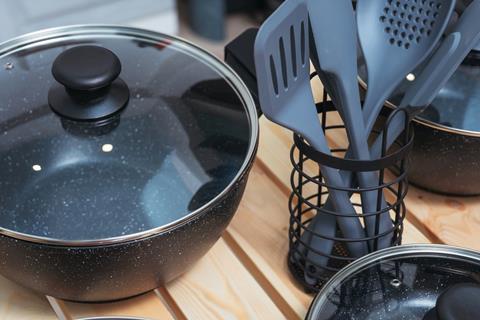 Plastic cooking utensils next to pots and pans.