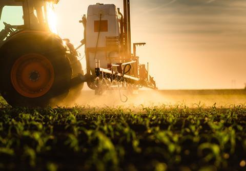 Tractor,Spraying,Pesticides,On,Corn,Field,With,Sprayer,At,Spring