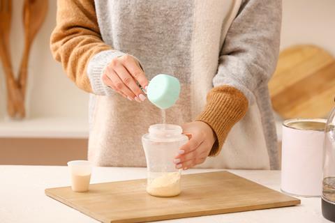 Woman,Preparing,Baby,Milk,Formula,In,Kitchen