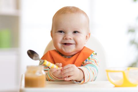 Cheerful,Baby,Child,Eats,Food,Itself,With,Spoon.,Portrait,Of