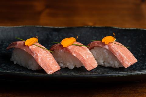 7 Trio of BlueNalu's bluefin tuna toro nigiri, topped with sliced chives and nasturtium petals