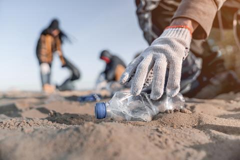 Volunteer,Man,Collecting,Trash,On,The,Beach.,Ecology,Concept