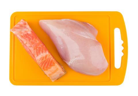 Piece,Of,Salmon,And,Raw,Chicken,Breast,On,Orange,Plastic