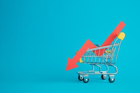 Shopping,Trolley,With,Red,Chart,Falling,Down,On,Blue,Background